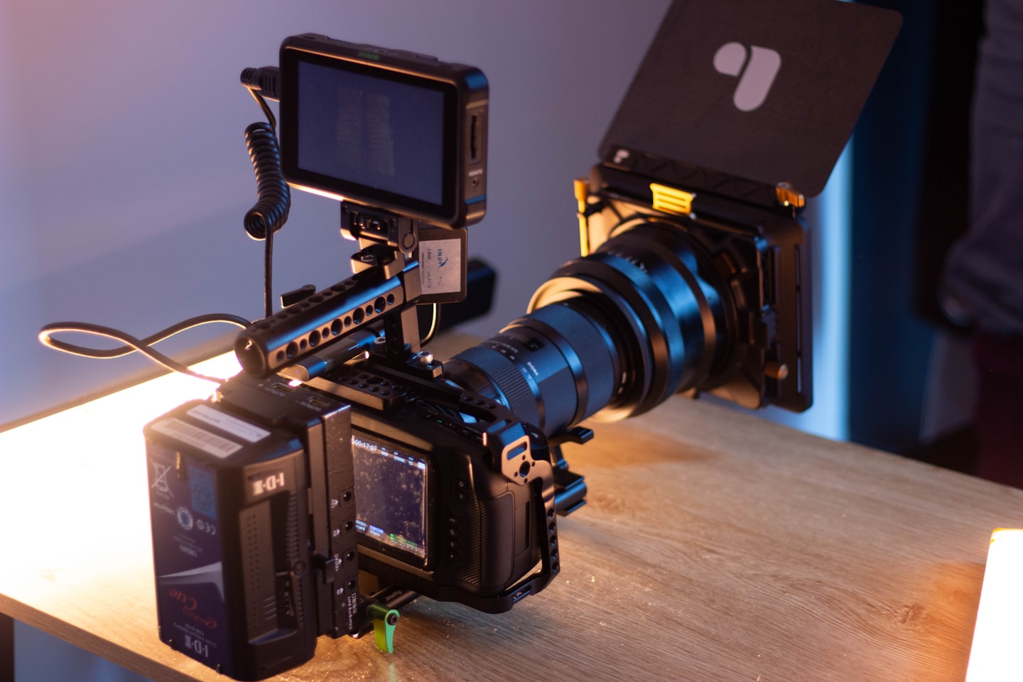Professional video camera equipment on a wooden table.